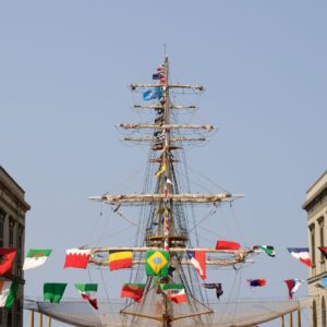 Ingresso dell’Accademia Navale di Livorno con torri gemelle e albero di nave decorato con bandiere, simbolo della Marina Militare Italiana.